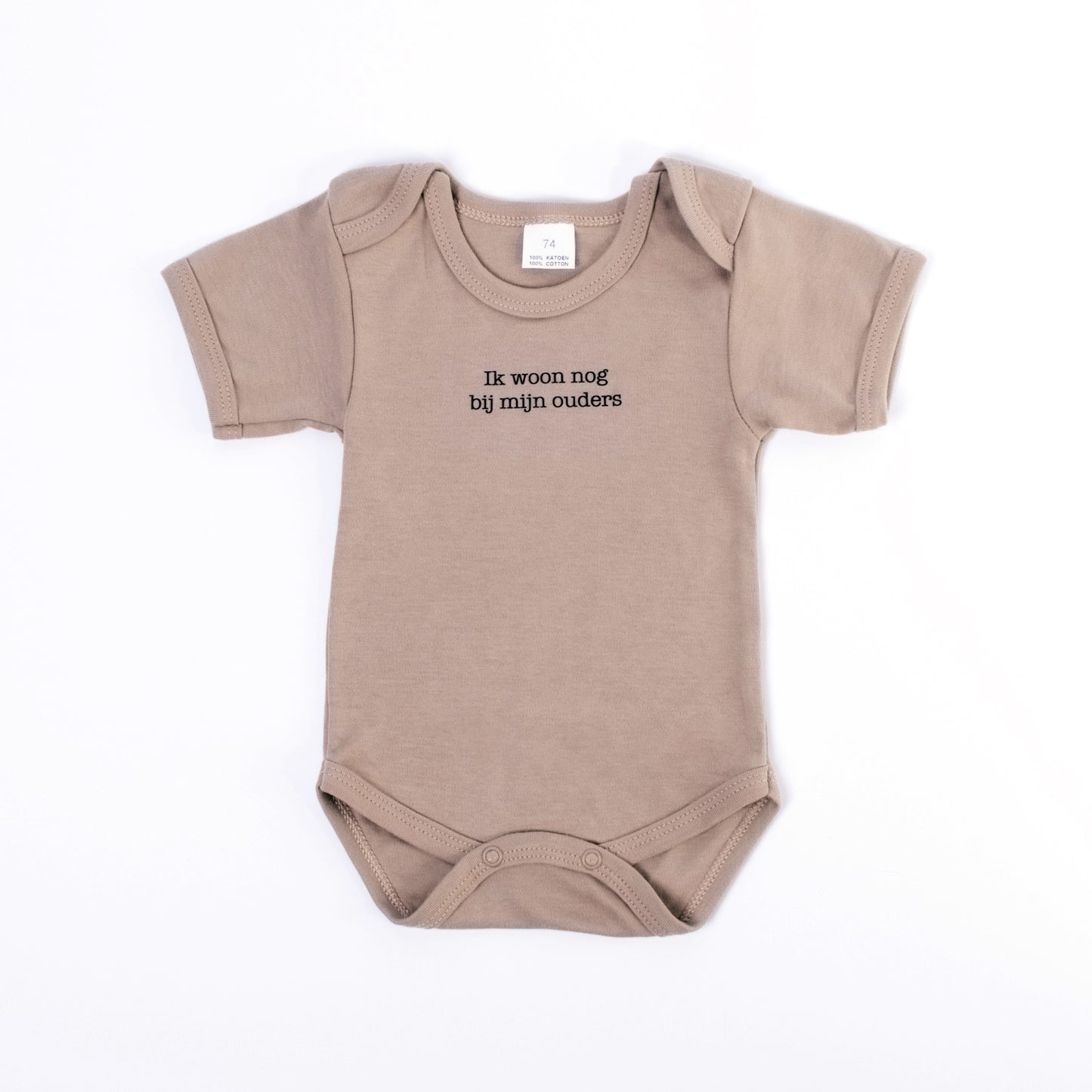 Beige body in neutrale tint met een grappig opschrift. Er staat de tekst 'ik woon nog bij mijn ouders'. Deze body voor baby's is leuk als kraamcadeau of cadeautje voor ouders van een kindje.