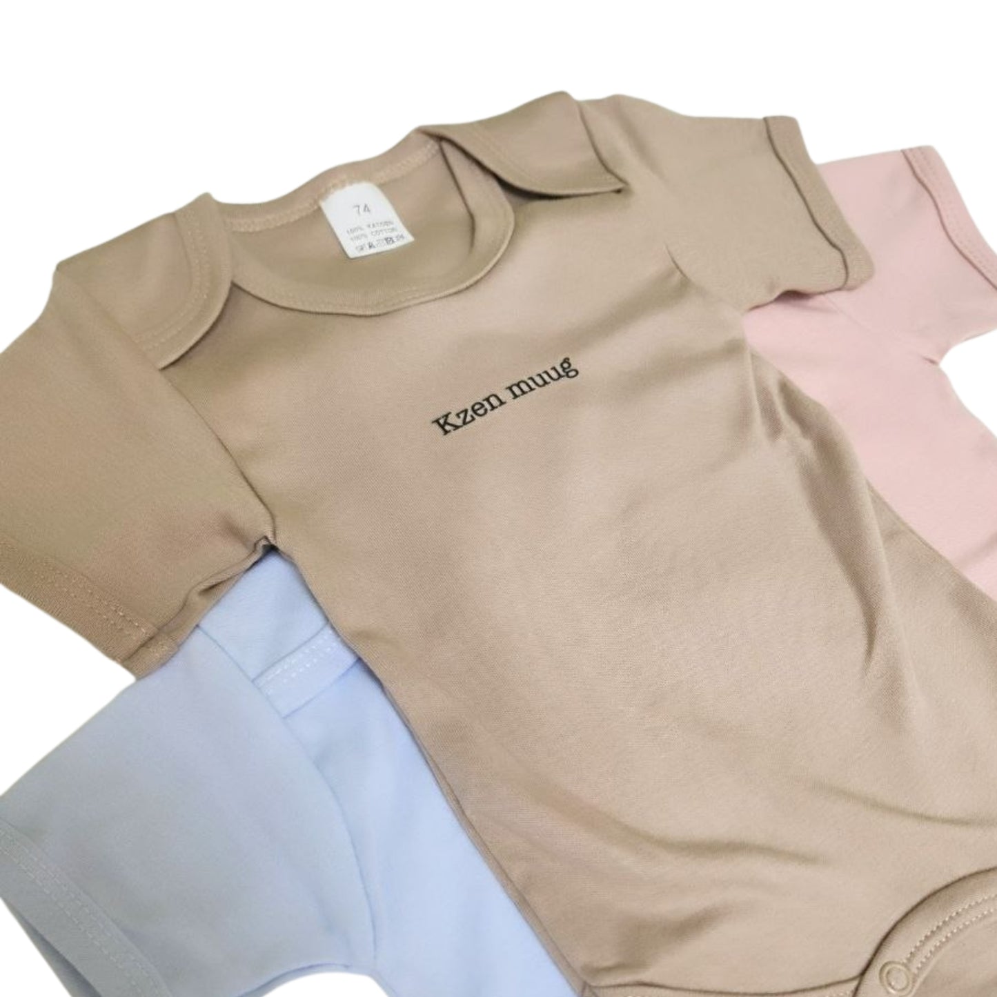 Drie body's op elkaar met de tekst 'kzen muug'. De body's zijn voor baby's en zijn beige, blauw en roze. Leuk als cadeautje!