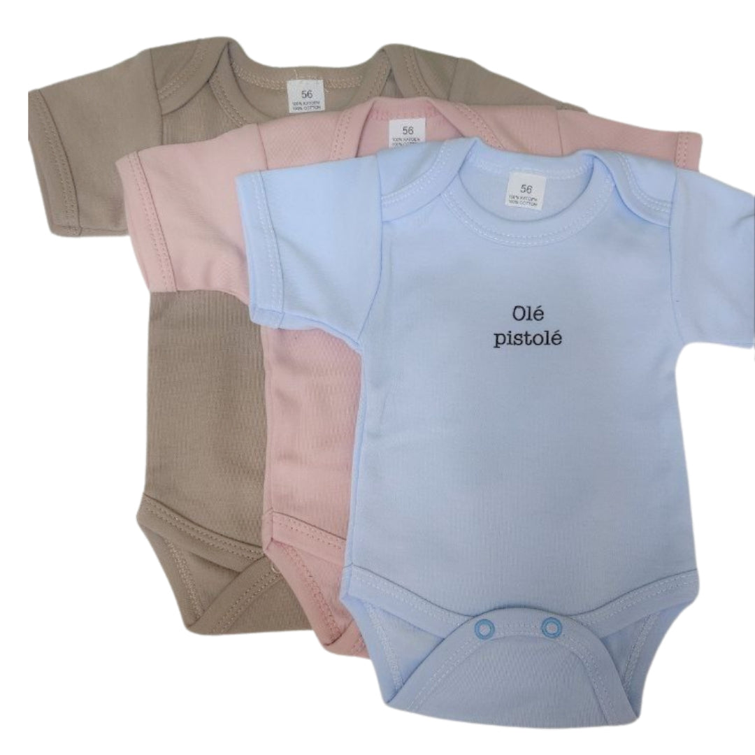 Drie body's voor baby's in de kleuren beige, roze en lichtblauw. Er staat de tekst 'olé pistolé' op geschreven. Een leuke body voor vrolijke baby's! Een orgineel en speels cadeau voor kleine kindjes en hun ouders!