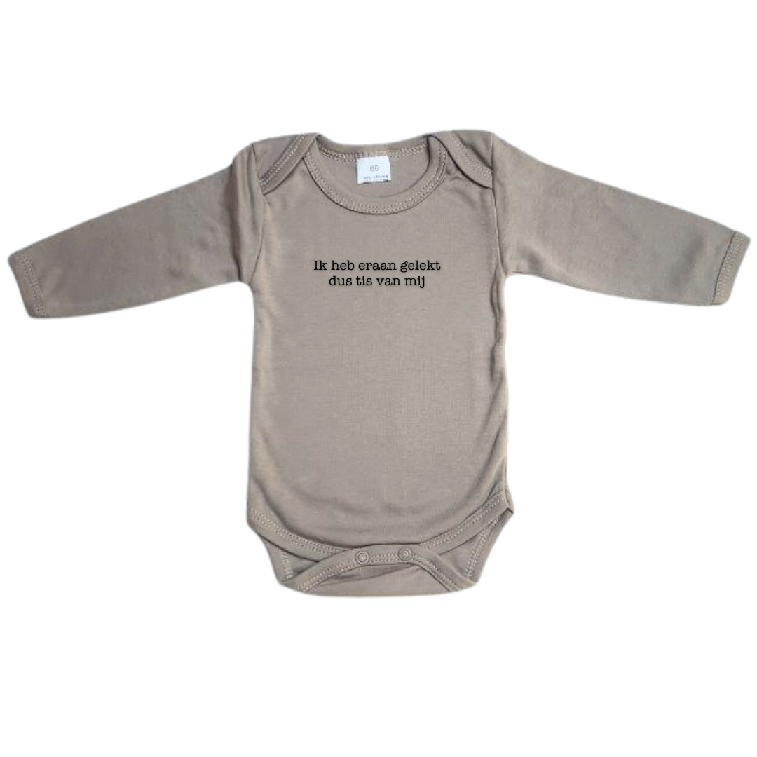 Beige body met lange mouwen met de tekst 'ik heb eraan gelekt dus tis van mij'. Deze grappige romper is een leuk kraamcadeau of perfect als cadeau voor ouders van pasgeboren kindjes. Ook leuk voor babyshowers!