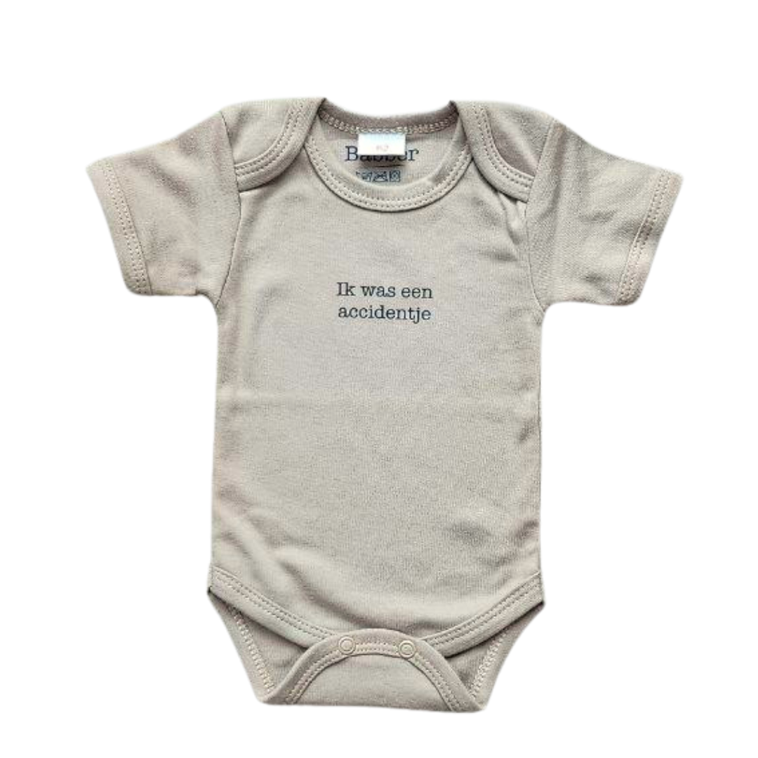 Beige body met de tekst 'ik was een accidentje'. Perfect om een zwangerschap of geboorte aan te kondigen op unieke, ludieke manier